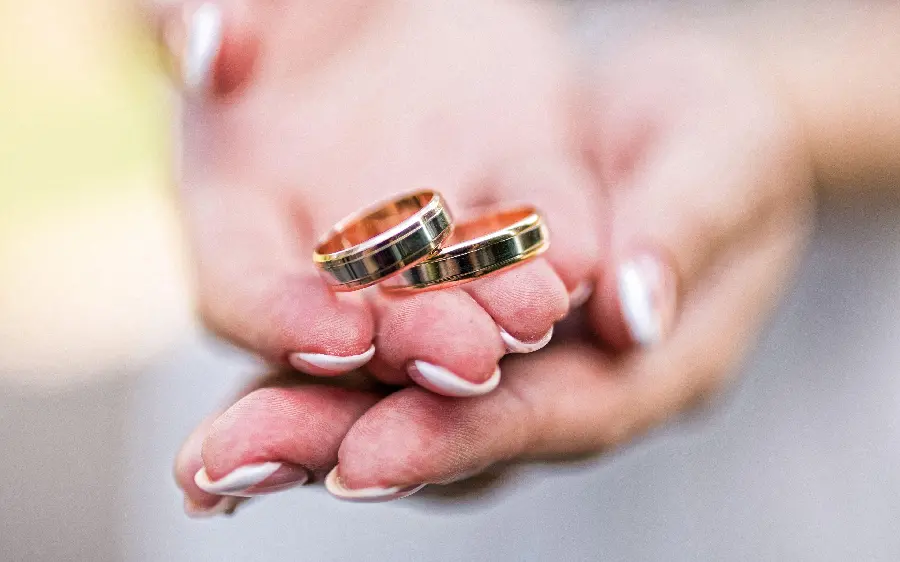 Profile photo of bride's hands with wedding rings set gold