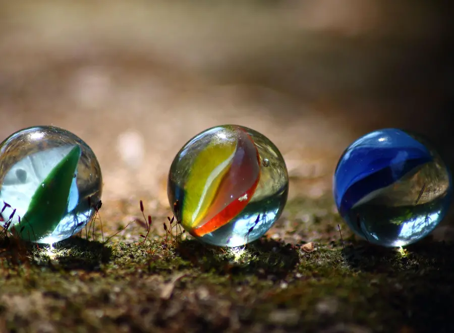 Image of 3 glass marbles in the reflection of sunlight