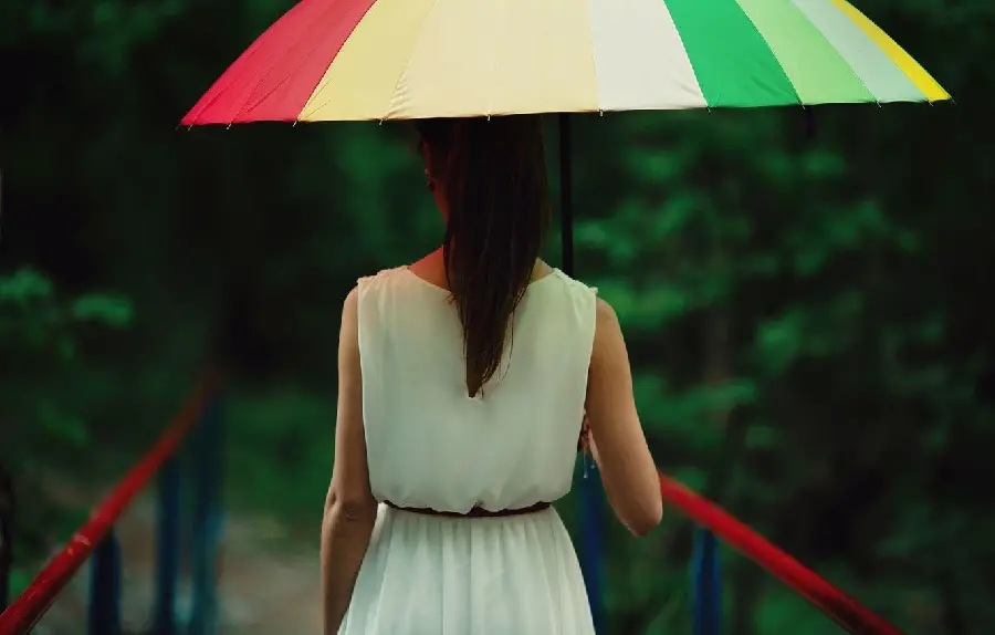 Real photo of a girl with a colorful umbrella in nature