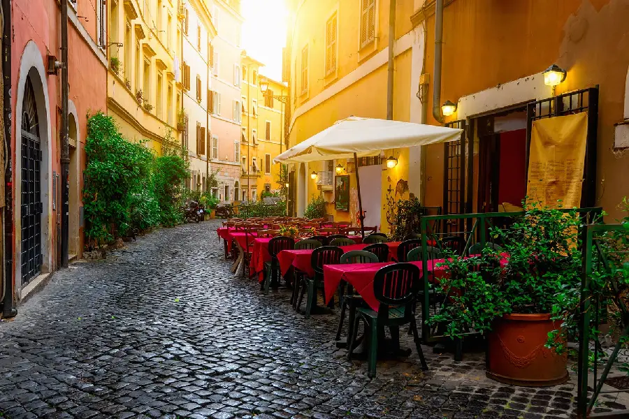 Photo of Italian cafes and red tables and chairs next to the street paving stones High quality image