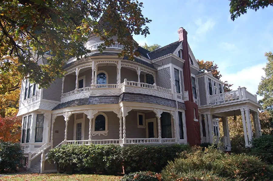 Photo of a building facade with curved details and complex shapes of large windows in Victorian architecture
