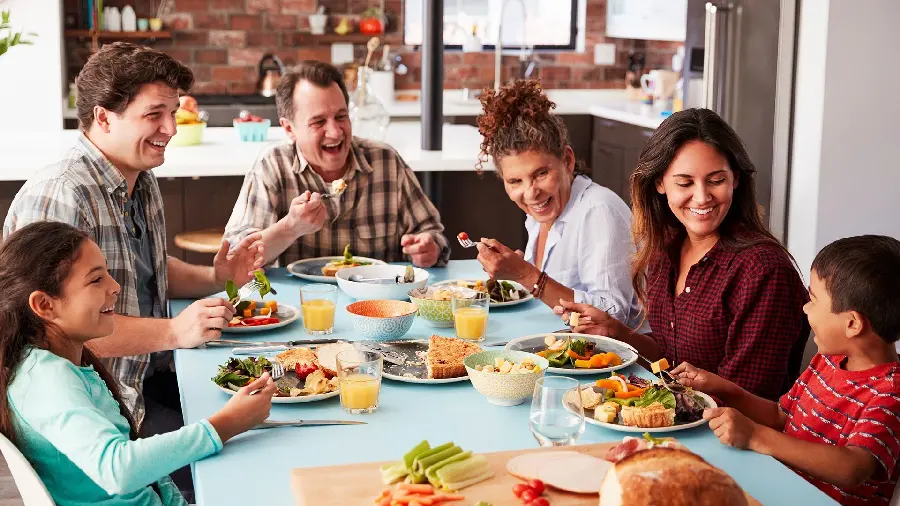 Happy family eating at the dinner table wallpaper